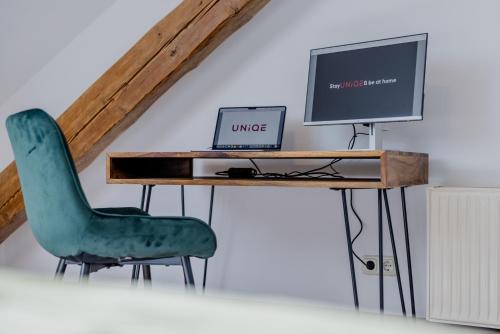 a desk with a computer and a green chair at UNiQE I 115qm I 3 Schlafzimmer I Nähe Messe in Haar