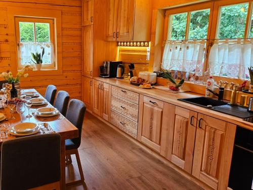 a kitchen with a long table and chairs in a room at Złoty Dom Brenna in Brenna