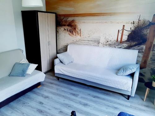 a living room with two white couches in a room at Apartament Kościuszki in Świnoujście