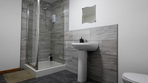 Un baño con ducha, lavabo e inodoro. en The Serenity Apartment, en Mánchester