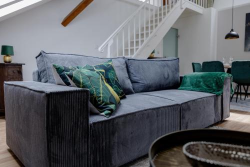 a blue couch with pillows in a living room at UNiQE I 115qm I 3 Schlafzimmer I Nähe Messe in Haar
