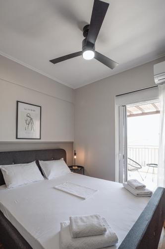 a bedroom with a large bed with a ceiling fan at NIMA Village in Paleros