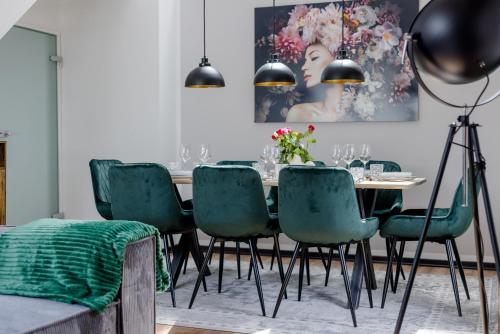 a dining room with a table and green chairs at UNiQE I 115qm I 3 Schlafzimmer I Nähe Messe in Haar