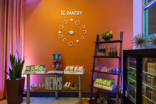 a store with an orange wall with a clock on it at Renaissance ClubSport Aliso Viejo Laguna Beach Hotel in Aliso Viejo