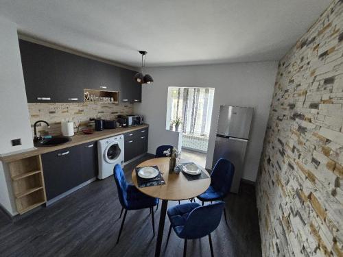 cocina con mesa y sillas azules en una habitación en Emiri Apartament, en Hunedoara
