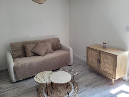 un salon avec un canapé et deux tables dans l'établissement Appartement en plein centre, à La Turballe