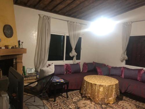 una sala de estar con un sofá y una mesa en FermeBao, en Settat