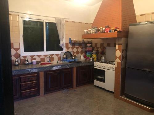 una cocina con fregadero y estufa en FermeBao, en Settat
