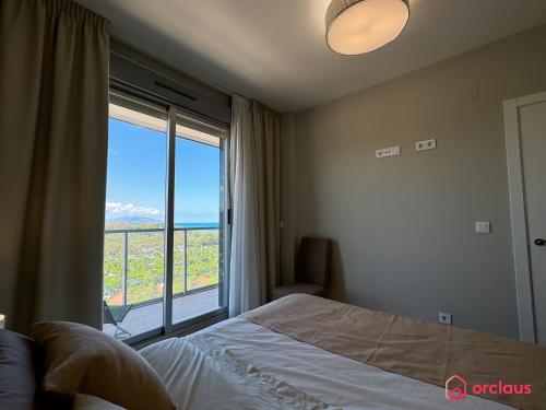 a bedroom with a bed and a large window at Verano Azul in Cabanes