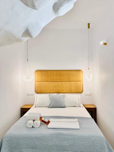 a bedroom with a bed with two towels on it at Gerani Deluxe Houses in Astypalaia Town