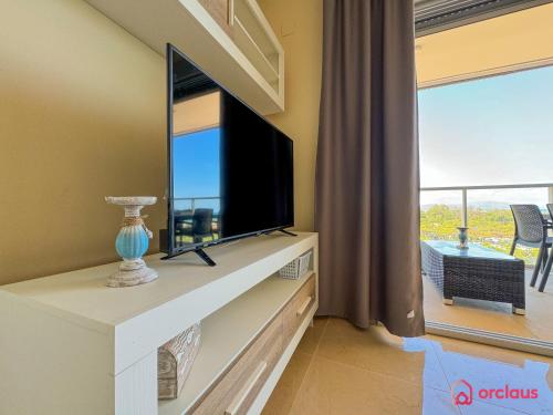 a living room with a flat screen tv on a dresser at Verano Azul in Cabanes