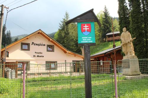 a sign in front of a building with a statue at Pension St. Maria in Staré Hory