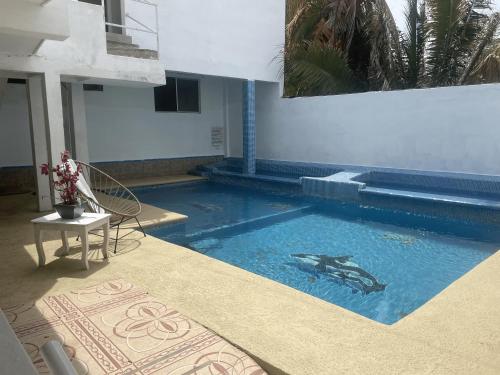 a swimming pool with a dolphin painted on the side of a building at Hotel Oasis Cuyutlan in Cuyutlán