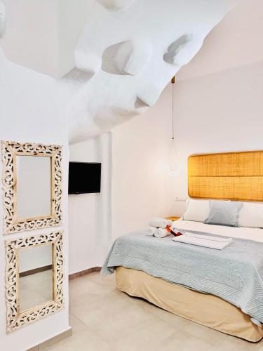 a bedroom with a bed and a mirror at Gerani Deluxe Houses in Astypalaia Town