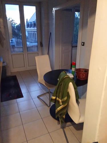 Cette chambre dispose d'une table, de chaises et d'un balcon. dans l'établissement Zimmer in eine whg in 63 rue des abeilles, à Mulhouse