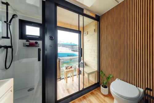 baño con aseo y vistas a la piscina en Domek na wodzie - Houseboat -sauna, taras na dachu, dwie sypialnie, en Mikołajki