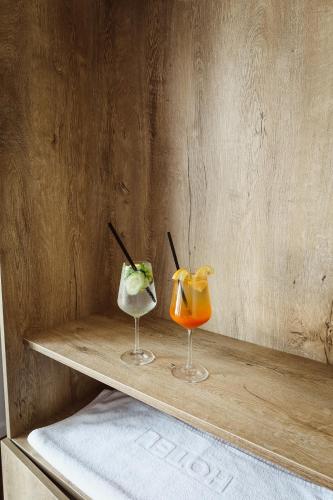 two cocktails sitting on a wooden shelf at Andoena Resort in Lipjan