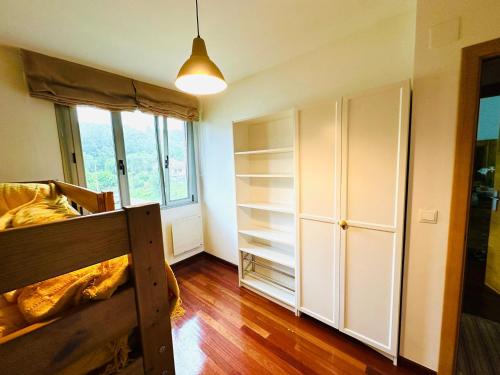 a bedroom with a bed and a large window at Elegante Adosado en Ampuero in Rasines