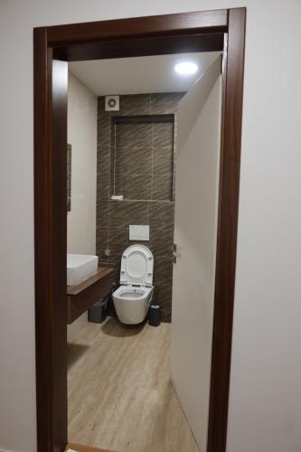 a bathroom with a toilet and a sink and a tub at Andoena Resort in Lipjan