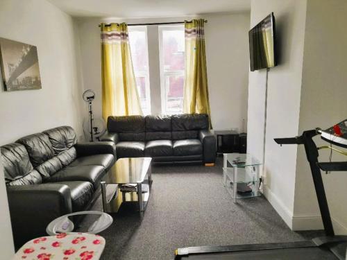 a living room with a leather couch and a table at ACCANE in Sunderland