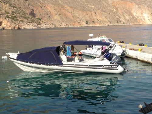 a small boat parked at a dock in the water at Athina Residence in Léntas