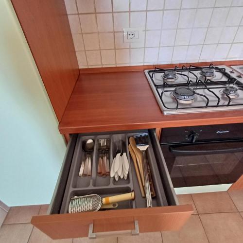 a kitchen with a stove and a drawer full of utensils at Ionio in Reggio Calabria