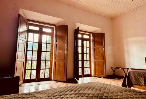 an empty room with doors and windows and a bed at Casa del Zocalo in Tlatlauquitepec