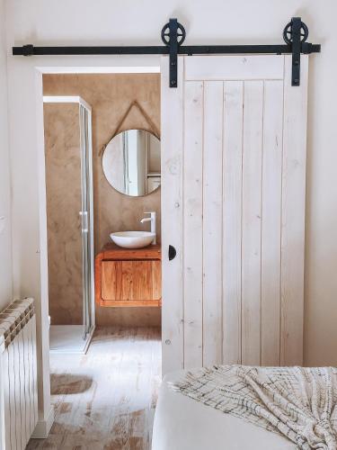 a bathroom with a white door and a sink at Captain Cook AHOY in Praia da Areia Branca
