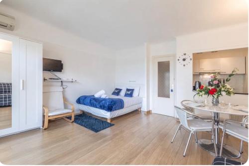 une chambre avec un lit, une table et des chaises dans l'établissement Appart 1 pièce pointe de la Croisette à cannes, à Cannes
