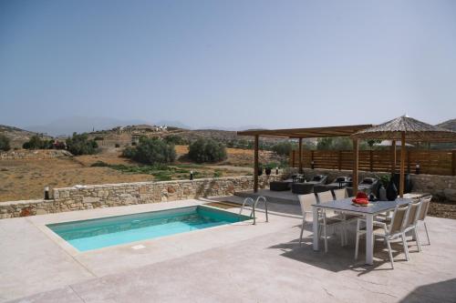 a patio with a table and a swimming pool at Kedros Katikies in Kalamaki Heraklion