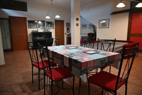 a dining room with a table with red chairs at Le Stelle Antiche - Giubileo 2025, concorsi aeronautica, Ryder Cup, Guidonia Montecelio, Roma, Tivoli in Marco Simone