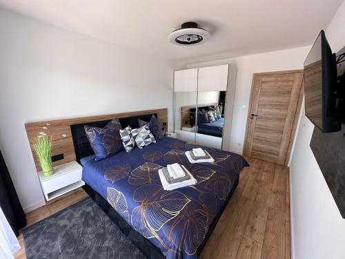 sypialnia z łóżkiem z niebieską kołdrą w obiekcie Solar Baltic Apartament by Resort&SPA Porta Mare Dziwnów w Dziwnowie