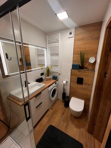 łazienka z umywalką i pralką w obiekcie Solar Baltic Apartament by Resort&SPA Porta Mare Dziwnów w Dziwnowie