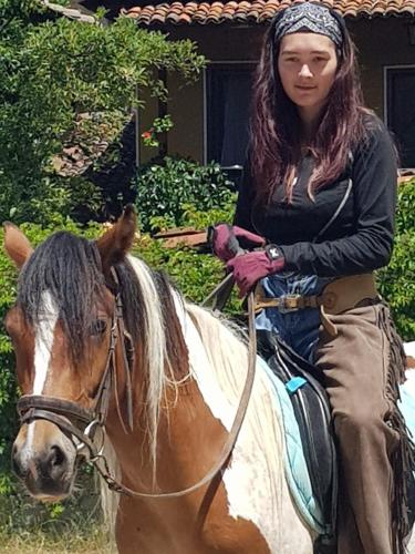 a woman riding on a brown and white horse at Dona Guest House - Horse Riding in Koprivshtitsa