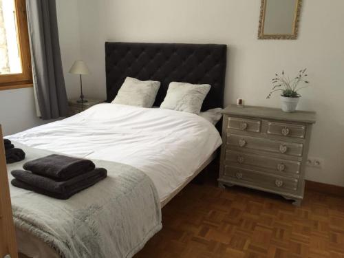 a bedroom with a bed with a black headboard and a dresser at Jangilau - Large, triple aspect apartment in central Morzine in Morzine