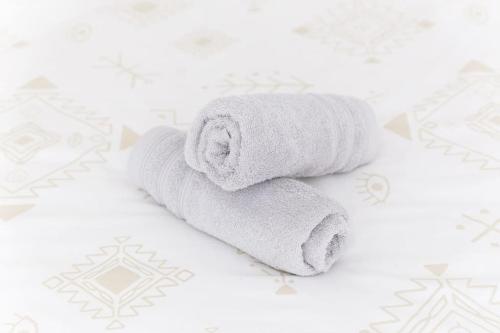 une pile de serviettes blanches posées sur un lit dans l'établissement Cocon Urbain - Proche Paris, à Saint-Ouen