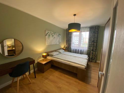 a small bedroom with a bed and a mirror at DiM Suwałki 11 Listopada in Suwałki