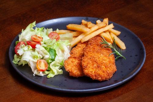 a blue plate of food with chicken and a salad and french fries at London Hotel Londrina in Londrina