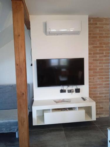 a white entertainment center with a flat screen tv on a wall at Merunky pod Palavou in Šakvice