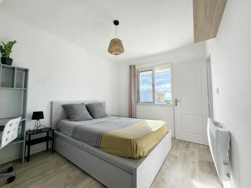 une chambre blanche avec un lit et une fenêtre dans l'établissement Appartement centre ville 4 personnes à Palavas les flots, à Palavas-les-Flots