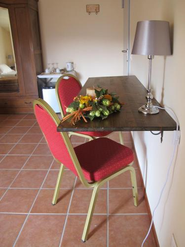 a table with two chairs and a table with flowers on it at Villa Cantoni in Gropello Cairoli