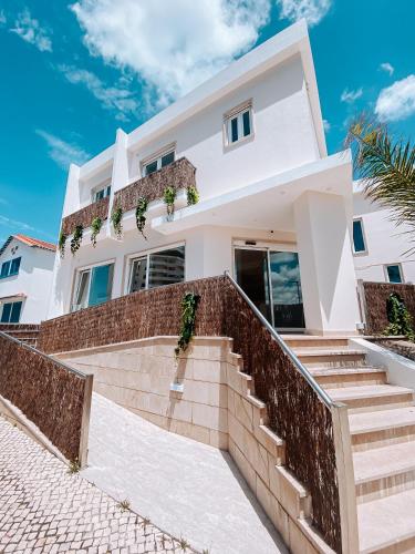 a white house with stairs in front of it at Captain Cook AHOY in Praia da Areia Branca
