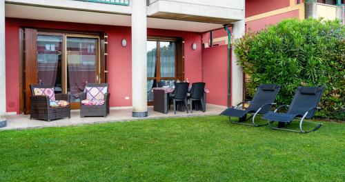 a group of chairs sitting outside of a building at Oleandro Apartment - Featuring a Private Garden and Access to 5 Pools in Desenzano del Garda