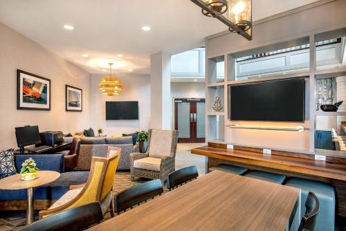 a living room with a large flat screen tv at Sheraton Portsmouth Harborside Hotel in Portsmouth