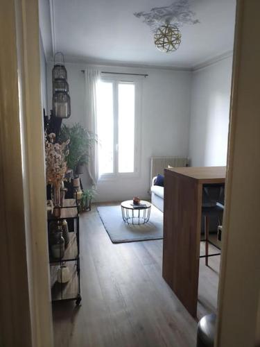 une vue d'un salon avec une table et d'une pièce avec un chercheur dans l'établissement Charmant deux pièces moderne, à Saint-Ouen