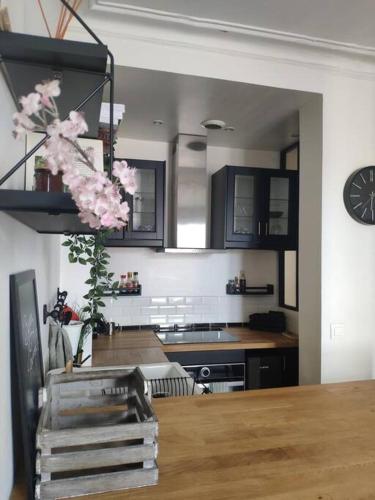 une cuisine avec une table avec un vase de fleurs dans l'établissement Charmant deux pièces moderne, à Saint-Ouen