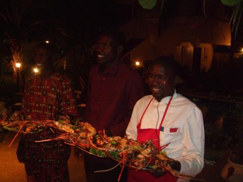 a group of people holding a tray of food at Maison Couleur Passion in Nianing