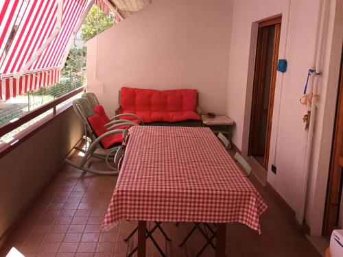 una mesa y sillas en una habitación con sofá rojo en CATA HOUSE, en Martinsicuro