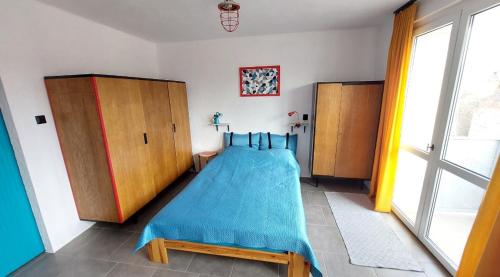 a bedroom with a bed with a blue blanket at Lovcik PRL in Głuchołazy
