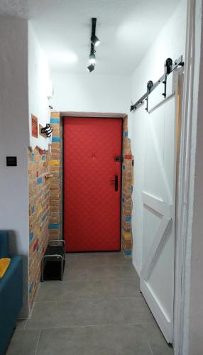 a red door in a room with a brick wall at Lovcik PRL in Głuchołazy